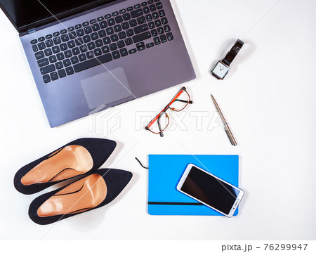 Office kit of businesswoman on the white background. Laptop, notebook, high heels, watches, glasses, smartphone etc. Close-up. Flat lay. Still life. Office kit of businesswoman on the white background. Laptop, notebook, high heels, watches, glasses, smartphone etc. Close-up. Flat lay. Still life. 76299947