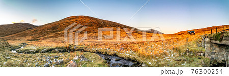 Old scratched Life buoy lying in the field in Ireland 76300254