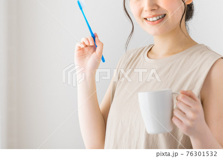 歯ブラシを持つ若い女性 76301532