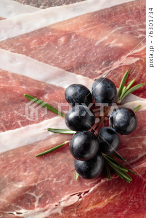 Prosciutto with grapes and rosemary. Prosciutto with grapes and rosemary. 76301734
