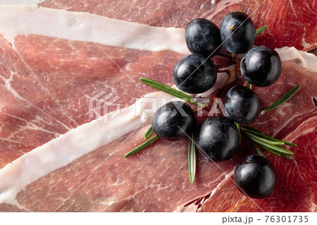 Prosciutto with grapes and rosemary. Prosciutto with grapes and rosemary. 76301735