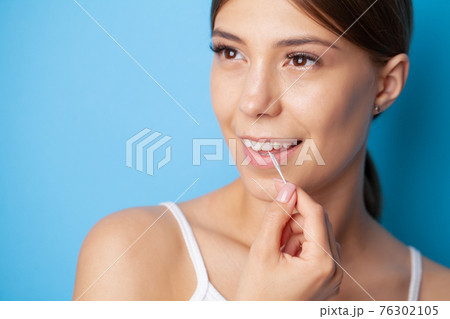 Woman uses brushes to clean the interdental spaces 76302105