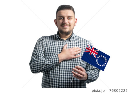 White guy holding a flag of Cook Islands and holds his hand on his heart isolated on a white background With love to Cook Islands 76302225