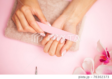 Woman hands receiving a manicure in beauty salon. Woman hands receiving a manicure in beauty salon. 76302373