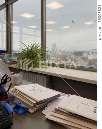Large thick folders with important papers and documents on the working office desk 76303321