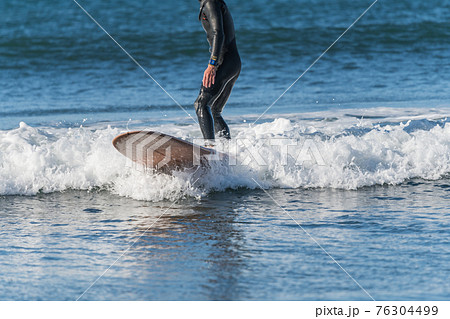 【強風吹き荒れる春の嵐の中のサーフィン】 76304499