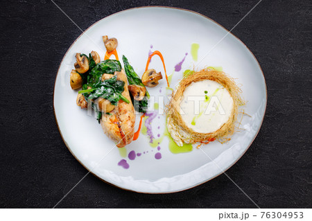 Chicken breasts with cheese and vegetable garnish 76304953