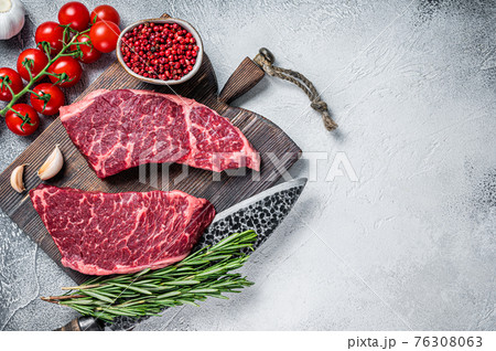 Raw denver cut black angus organic steak on a butcher cutting board with herbs. White background. Top view. Copy space Raw denver cut black angus organic steak on a butcher cutting board with herbs. White background. Top view. Copy space 76308063