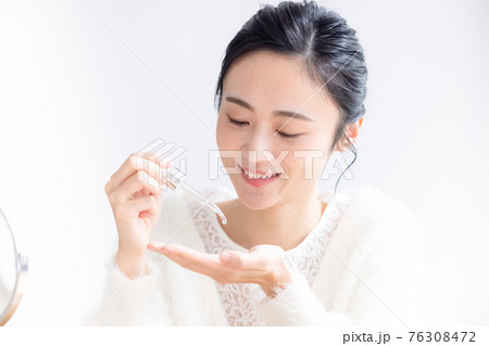 ビューティーイメージ　美容液を手に垂らす女性 76308472