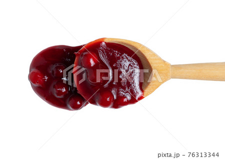 Homemade sauce made from fresh wild lingonberry drips from a spoon. Isolated on white background, top view 76313344