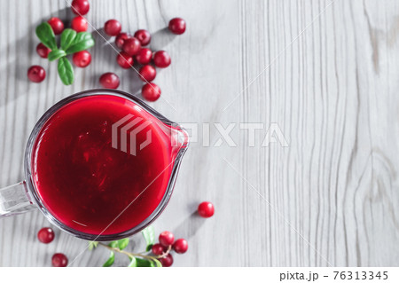 Homemade fresh wild lingonberry sauce in a glass gravy boat, top view, flat lay, copyspace 76313345