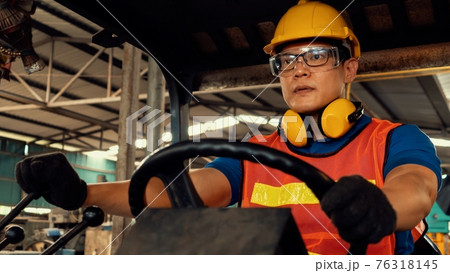 Skillful worker drives forklift in the factory . 76318145
