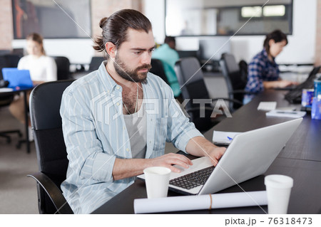 Serious guy working with laptop 76318473