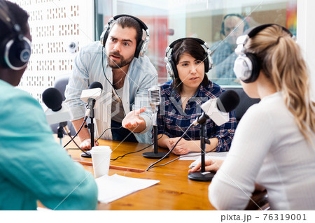 Scandal interview. Two outraged guests answering provocative questions of radio hosts during live radio show Scandal interview. Two outraged guests answering provocative questions of radio hosts during live radio show 76319001