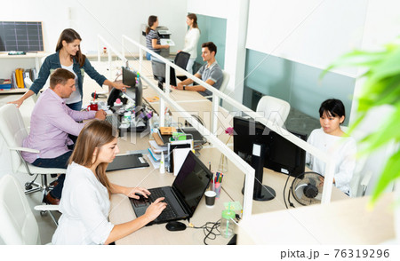 People working with computers and laptops in modern office 76319296
