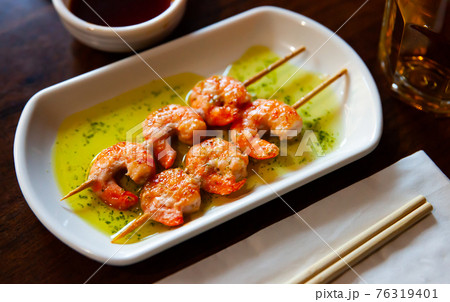 Plate grilled king prawn kebabs on skewers 76319401
