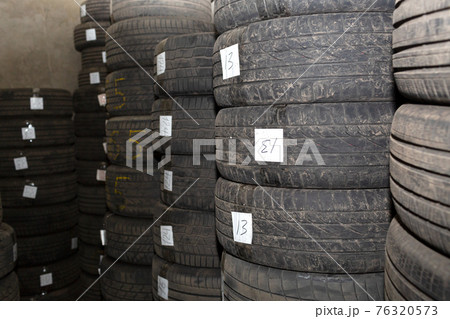 Storage dirty car tires. Pile of old used rubber tires. Warehouse. Storage dirty car tires. Pile of old used rubber tires. Warehouse. 76320573