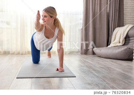 Young pregnant caucasian woman training yoga at home Young pregnant caucasian woman training yoga at home 76320834