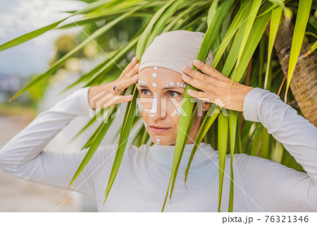Kundalini yoga woman in white clothes and turban practices yoga kundalini on the background of the sea, mountains and sunset. Fighting face painting of the Indians shows her inner world. Visual 76321346