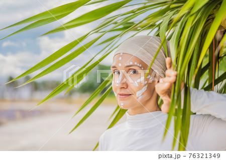 Kundalini yoga woman in white clothes and turban practices yoga kundalini on the background of the sea, mountains and sunset. Fighting face painting of the Indians shows her inner world. Visual 76321349