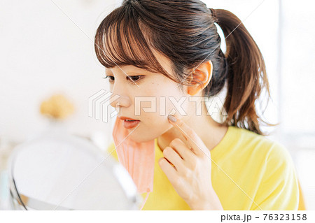 マスクを外して肌荒れを気にする女性 マスクを外して肌荒れを気にする女性 76323158