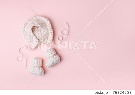 Pale pastel cute baby handknitted bonnet and booties socks. Set of kids clothes and accessories. Fashion newborn. Flat lay, top view. Handmade clothes, Girl baby shower, first birthday gifts 76324258