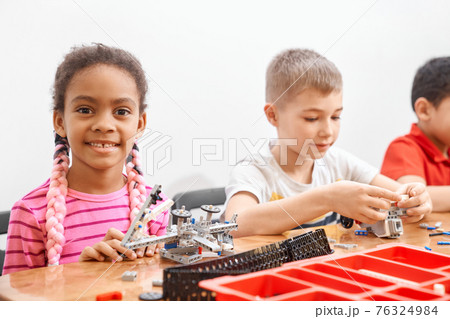 Kids working on project using building kit. 76324984
