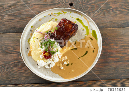 Grilled steak with mashed potatoes and sauce. 76325025