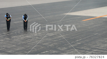 Airport staff bowing on airport runway, Okinawa, Japan Airport staff bowing on airport runway, Okinawa, Japan 76327824