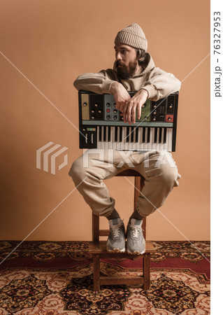 Full-length portrait of man, musician isolated on light yellow background. 76327953