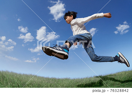 青空を背景にジャンプする少年 青空を背景にジャンプする少年 76328842