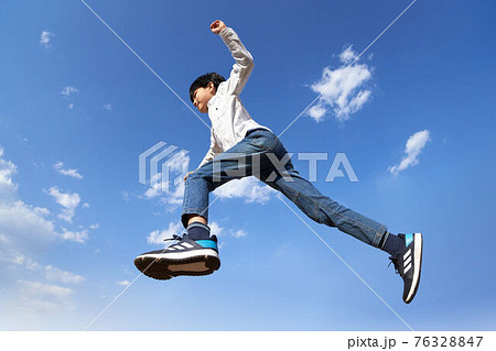 青空を背景にジャンプする少年 青空を背景にジャンプする少年 76328847