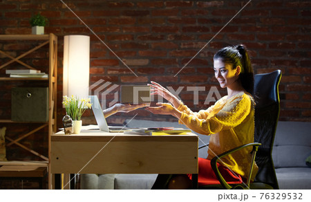 Young Caucasian woman talking with friend online through laptop. Young Caucasian woman talking with friend online through laptop. 76329532
