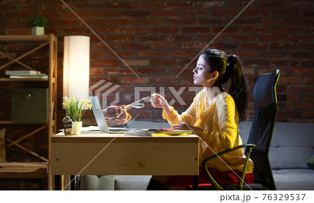 Young Caucasian woman talking with friend online through laptop. Young Caucasian woman talking with friend online through laptop. 76329537