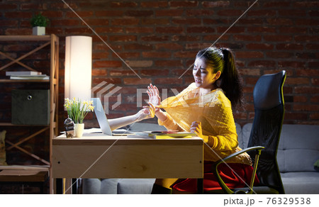 Young Caucasian woman talking with friend online through laptop. 76329538