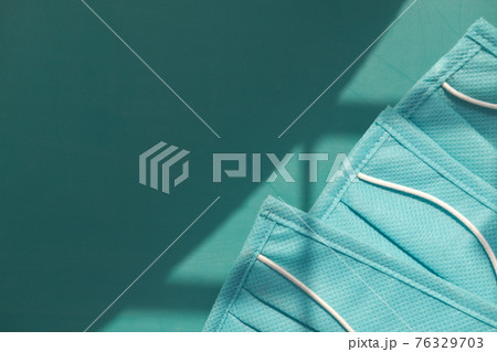 Close up of green surgical masks on color background with copy space  76329703