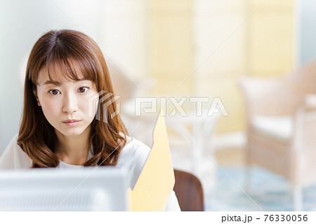 明るい室内でデスクワーク中の女性 明るい室内でデスクワーク中の女性 76330056