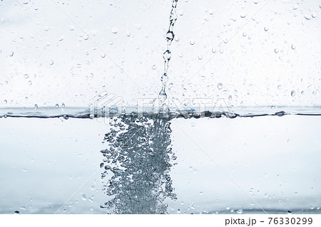 白い背景に水の中に落ちる水滴の写真素材