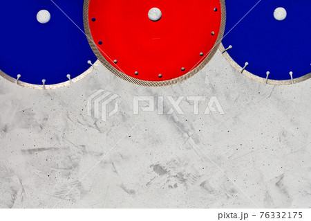 Cutting diamond discs of blue and red color on a gray concrete background. Cutting diamond discs of blue and red color on a gray concrete background. 76332175