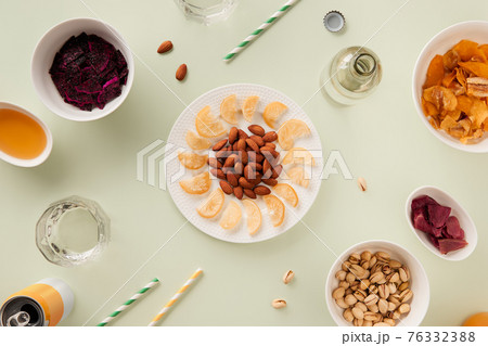 Dried fruits and nuts with sauce on green background with sunlight Dried fruits and nuts with sauce on green background with sunlight 76332388