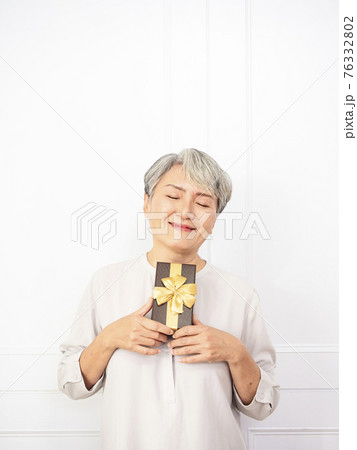 Senior asian woman happy smile hold gift box in hands. Senior asian woman happy smile hold gift box in hands. 76332802