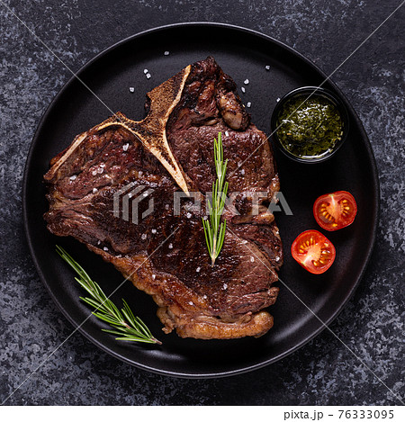 Grilled beef steak with spices on a black plate Grilled beef steak with spices on a black plate 76333095