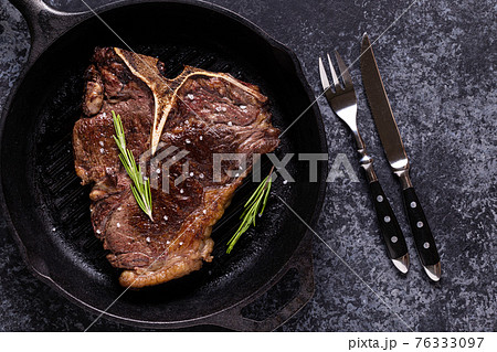 Grilled beef steak with spices in a frying pan 76333097