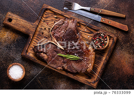 Grilled beef steak with spices on a wooden board 76333099