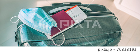 Travel during covid-19 with surgical face mask and tourist luggage panoramic banner. Plane ticket with passport. Travel during covid-19 with surgical face mask and tourist luggage panoramic banner. Plane ticket with passport. 76333193