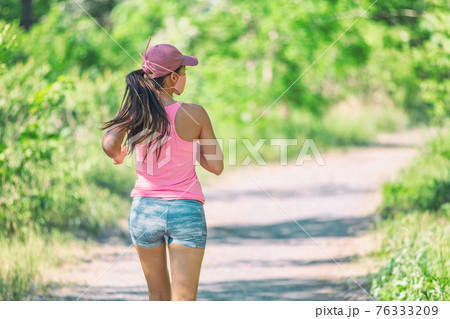 Runner running outdoor wearing protective face mask during active workout outside for COVID-19 prevention in public. Outdoor summer lifestyle. 76333209