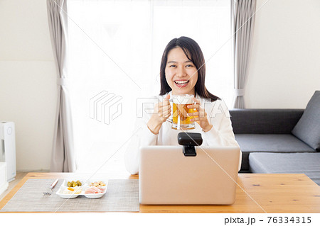 オンライン飲み会をする若い女性 76334315