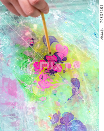 mixing of dyes on surface of liquid in basin 76337105