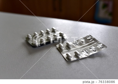 Pills in packpage on table. Medicine grade pharmaceutical tablets. Medical pill for maintaining Pills in packpage on table. Medicine grade pharmaceutical tablets. Medical pill for maintaining 76338086