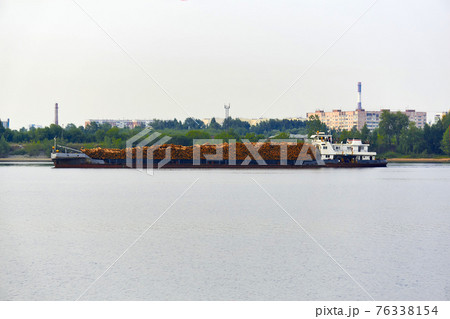 river timber carrier ship loaded with logs moves past the urban coast river timber carrier ship loaded with logs moves past the urban coast 76338154
